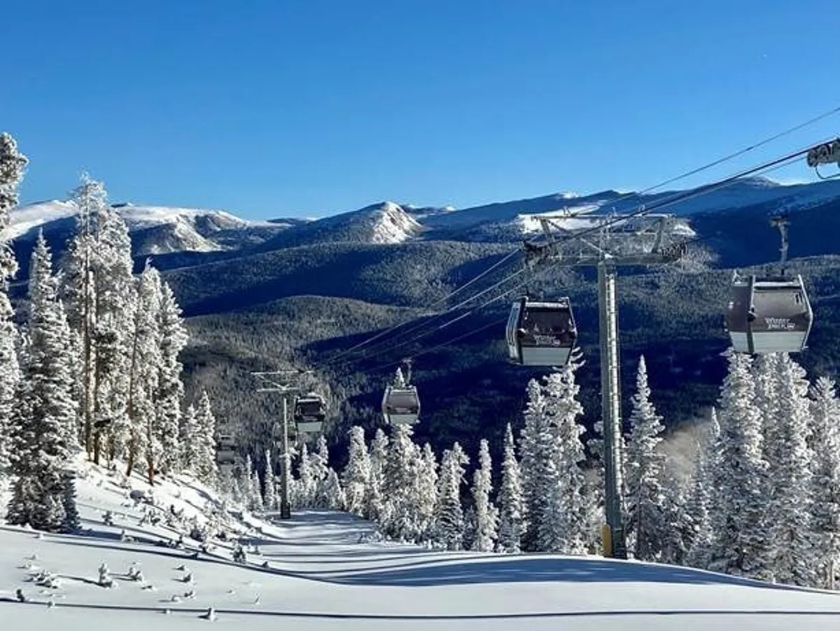 This exterior image features a ski lift ascending a snow-blanketed mountain, surrounded by tall, snow-covered trees. The backdrop showcases dramatic mountain peaks, conveying both adventure and tranquility. The scene captures the thrill of winter activities and the beauty of immediate access to nature.